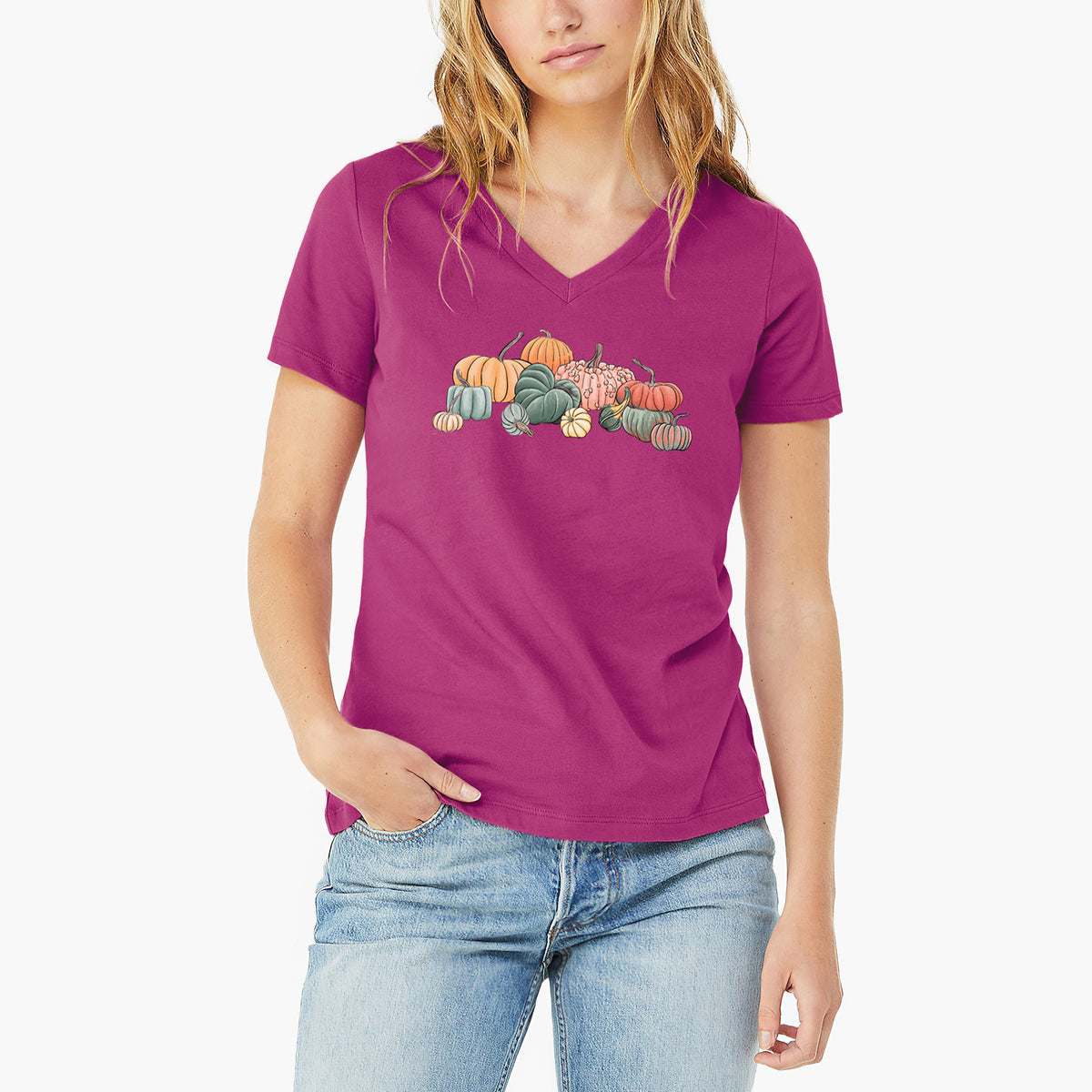 Woman wearing a berry pink women's relaxed fit cotton V-neck t-shirt printed with a full-color illustration of a pile of pumpkins and gourds in orange, green and white.