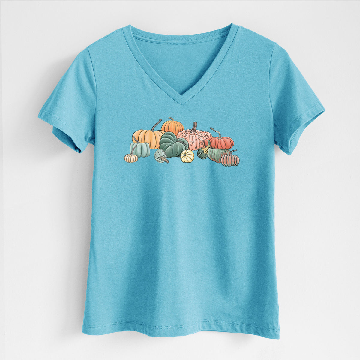 Turquoise women's relaxed fit cotton V-neck t-shirt laid flat, printed with a full-color illustration of a pile of pumpkins and gourds in orange, green and white.