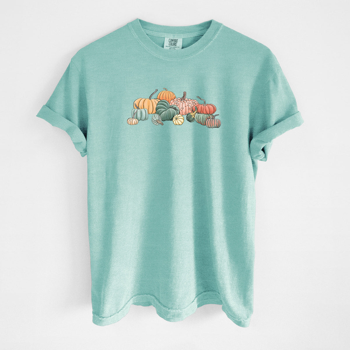 Chalky mint Comfort Colors t-shirt laid flat, printed with a full-color illustration of a pile of pumpkins and gourds in orange, green and white.