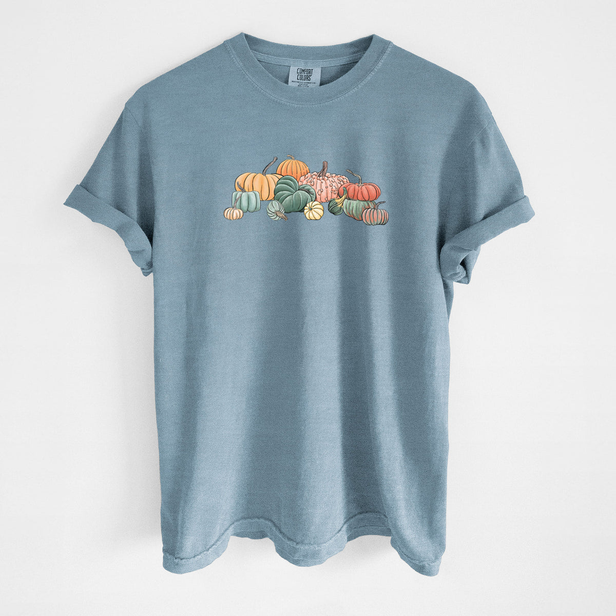 Steel blue Comfort Colors t-shirt laid flat, printed with a full-color illustration of a pile of pumpkins and gourds in orange, green and white.