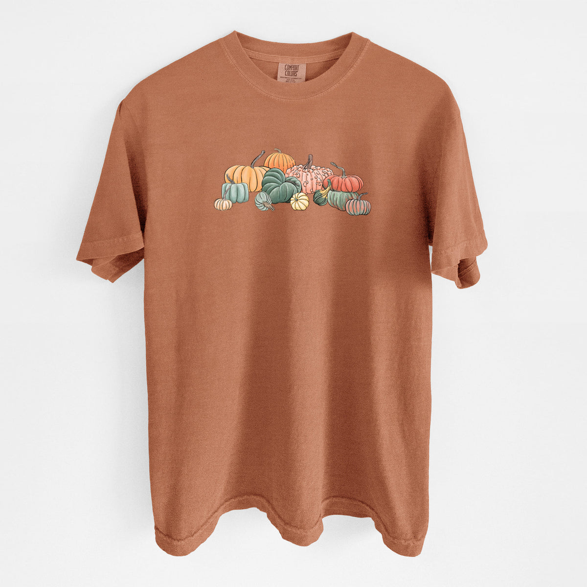 Yam burnt orange Comfort Colors t-shirt laid flat, printed with a full-color illustration of a pile of pumpkins and gourds in orange, green and white.