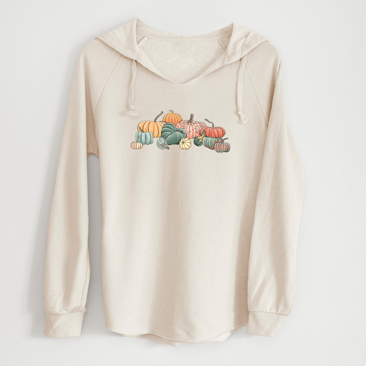 Bone cream women's Cali Wave hooded sweatshirt laid flat, printed with a full-color illustration of a pile of pumpkins and gourds in orange, green and white.