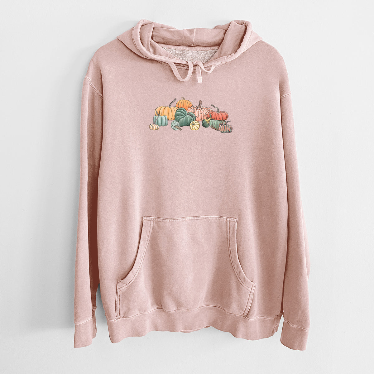 Dusty pink pigment dyed hoodie laid flat, printed with a full-color illustration of a pile of pumpkins and gourds in orange, green and white.