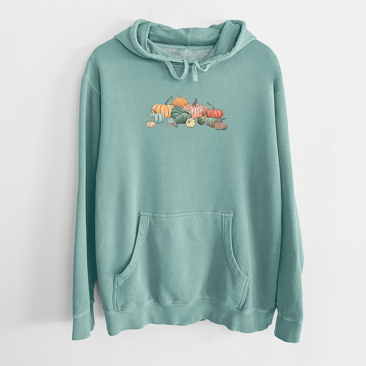 Mint green pigment dyed hoodie laid flat, printed with a full-color illustration of a pile of pumpkins and gourds in orange, green and white.