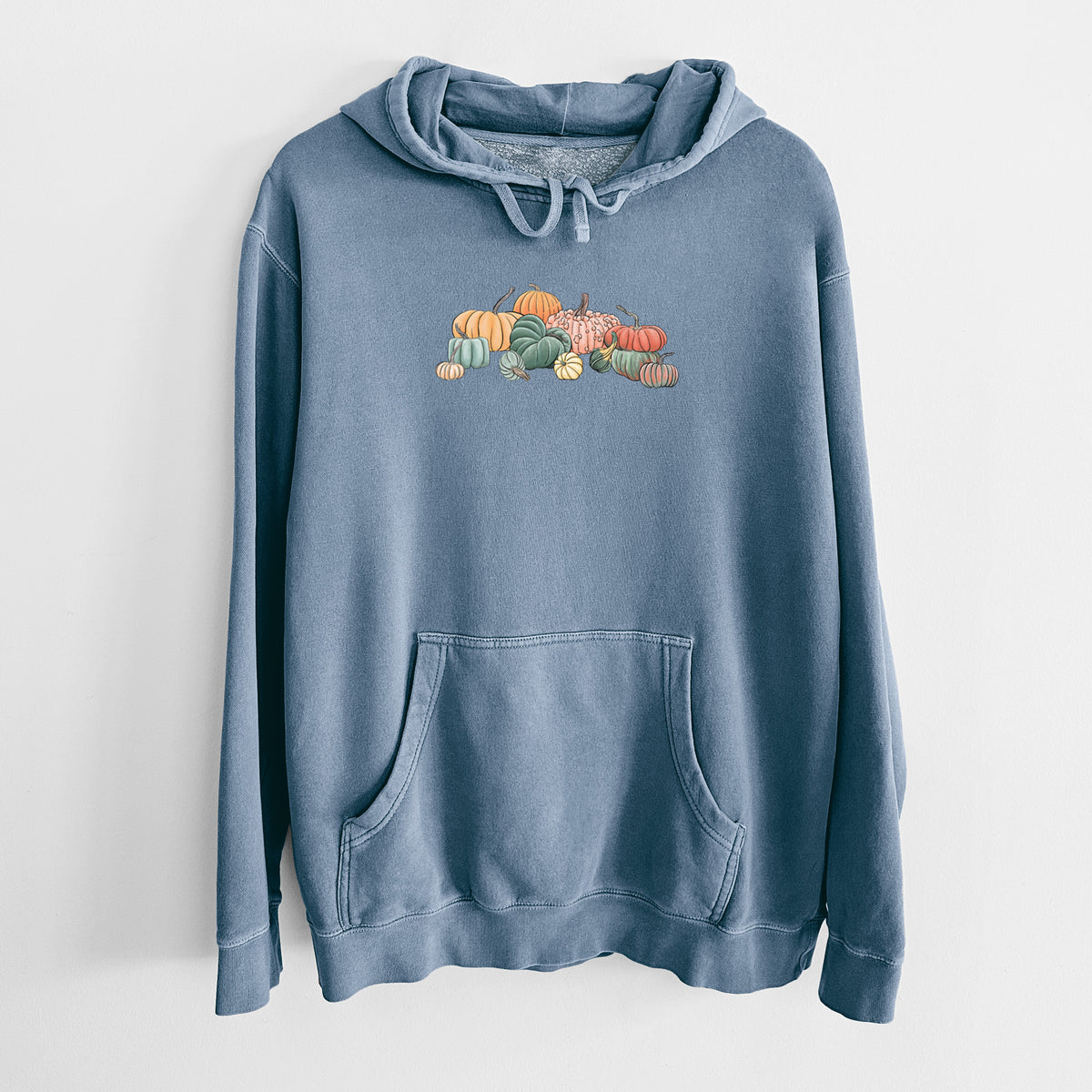 Slate blue pigment dyed hoodie laid flat, printed with a full-color illustration of a pile of pumpkins and gourds in orange, green and white.