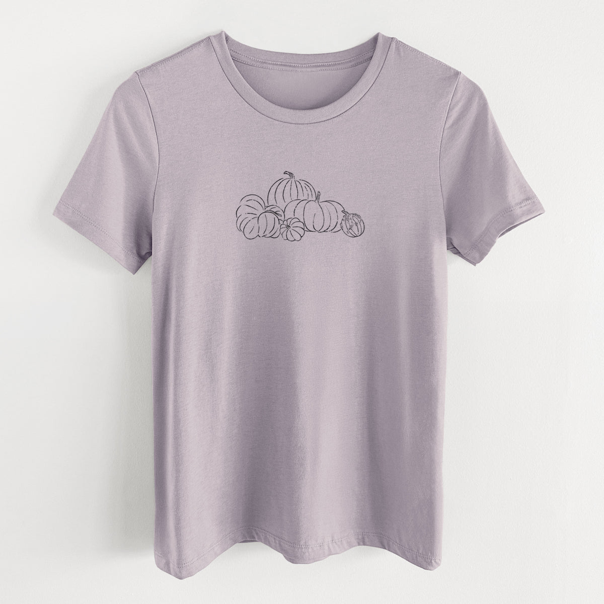 Light violet women's relaxed fit cotton t-shirt laid flat, printed with a black ink line drawing of a pile of pumpkins.