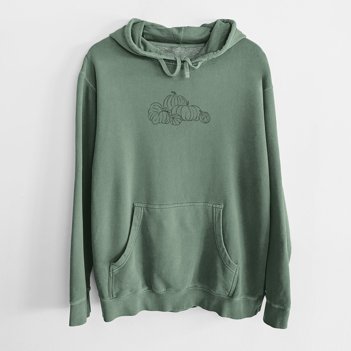 Alpine green pigment dyed hoodie laid flat, printed with a black ink line drawing of a pile of pumpkins.