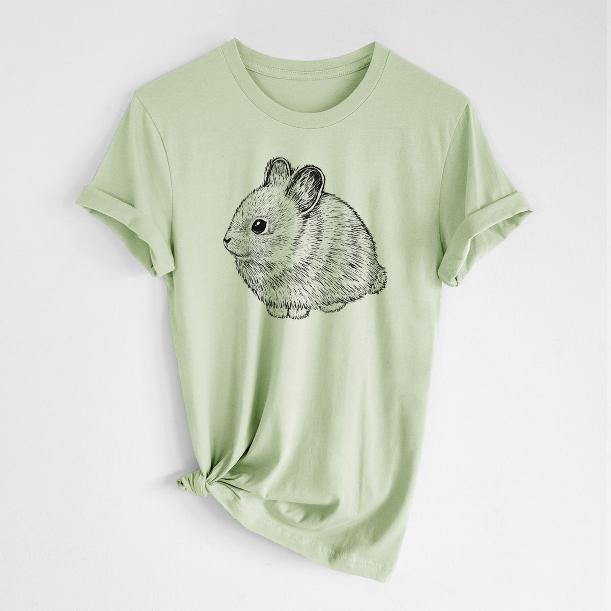 Spring green lightweight cotton t-shirt laid flat with the sleeves rolled, printed with a detailed black ink illustration of a round, fluffy pygmy rabbit.