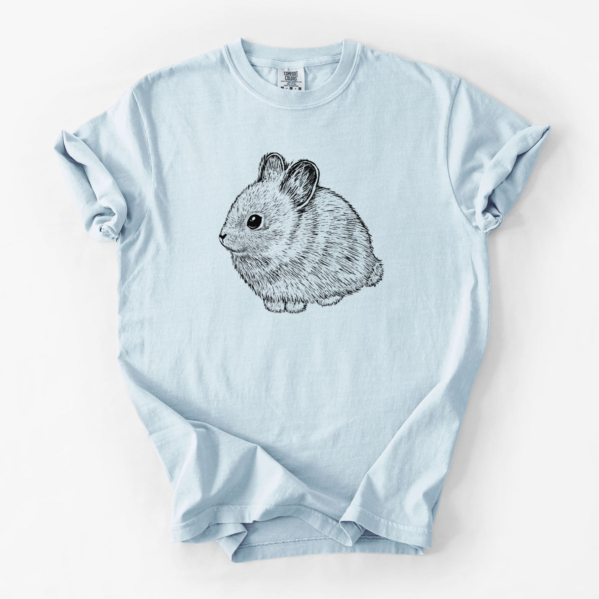 Chambray blue Comfort Colors t-shirt laid flat, printed with a detailed black ink illustration of a round, fluffy pygmy rabbit.