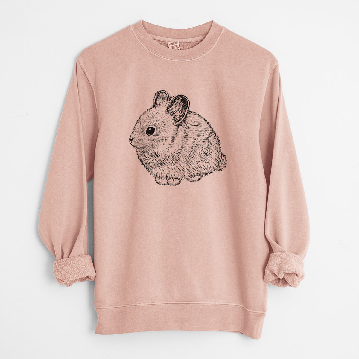Dusty pink pigment dyed crewneck sweatshirt laid flat with the sleeves rolled, printed with a detailed black ink illustration of a round, fluffy pygmy rabbit.