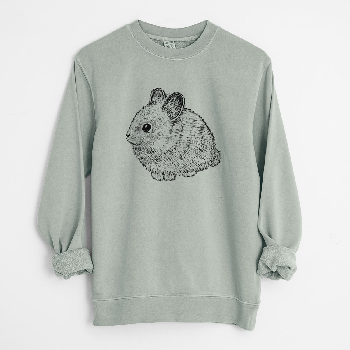 Sage green pigment dyed crewneck sweatshirt laid flat with the sleeves rolled, printed with a detailed black ink illustration of a round, fluffy pygmy rabbit.