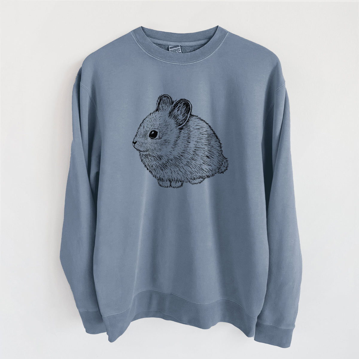 Slate blue pigment dyed crewneck sweatshirt laid flat, printed with a detailed black ink illustration of a round, fluffy pygmy rabbit.