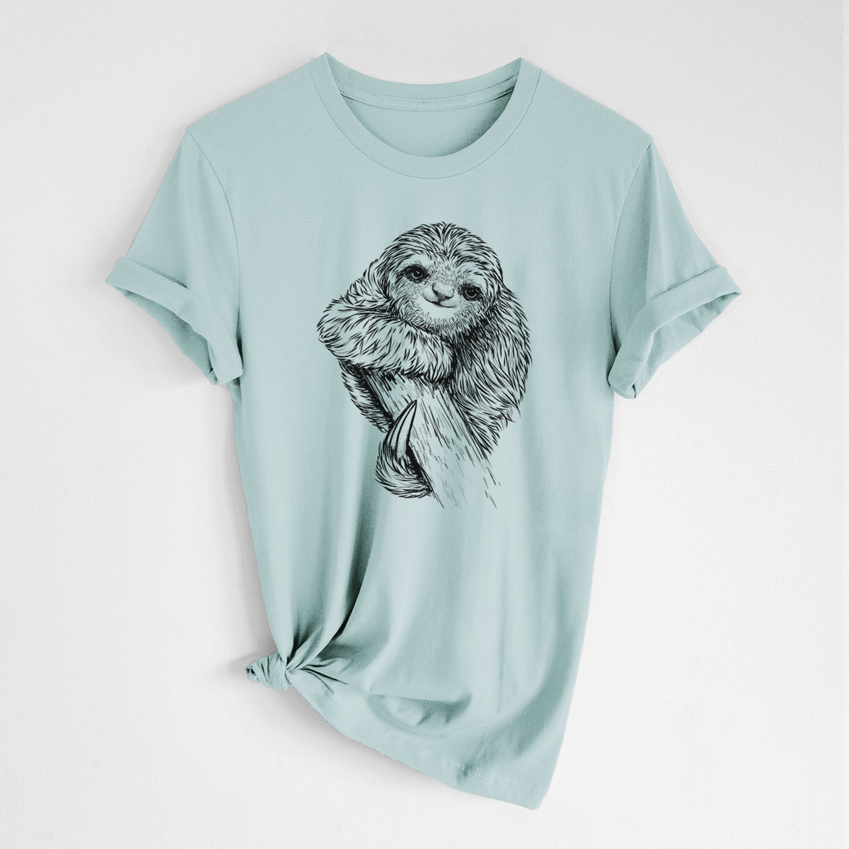 Dusty blue lightweight cotton t-shirt laid flat with the sleeves rolled, printed with a detailed black ink illustration of a smiling pygmy three-toed sloth hanging from a branch.