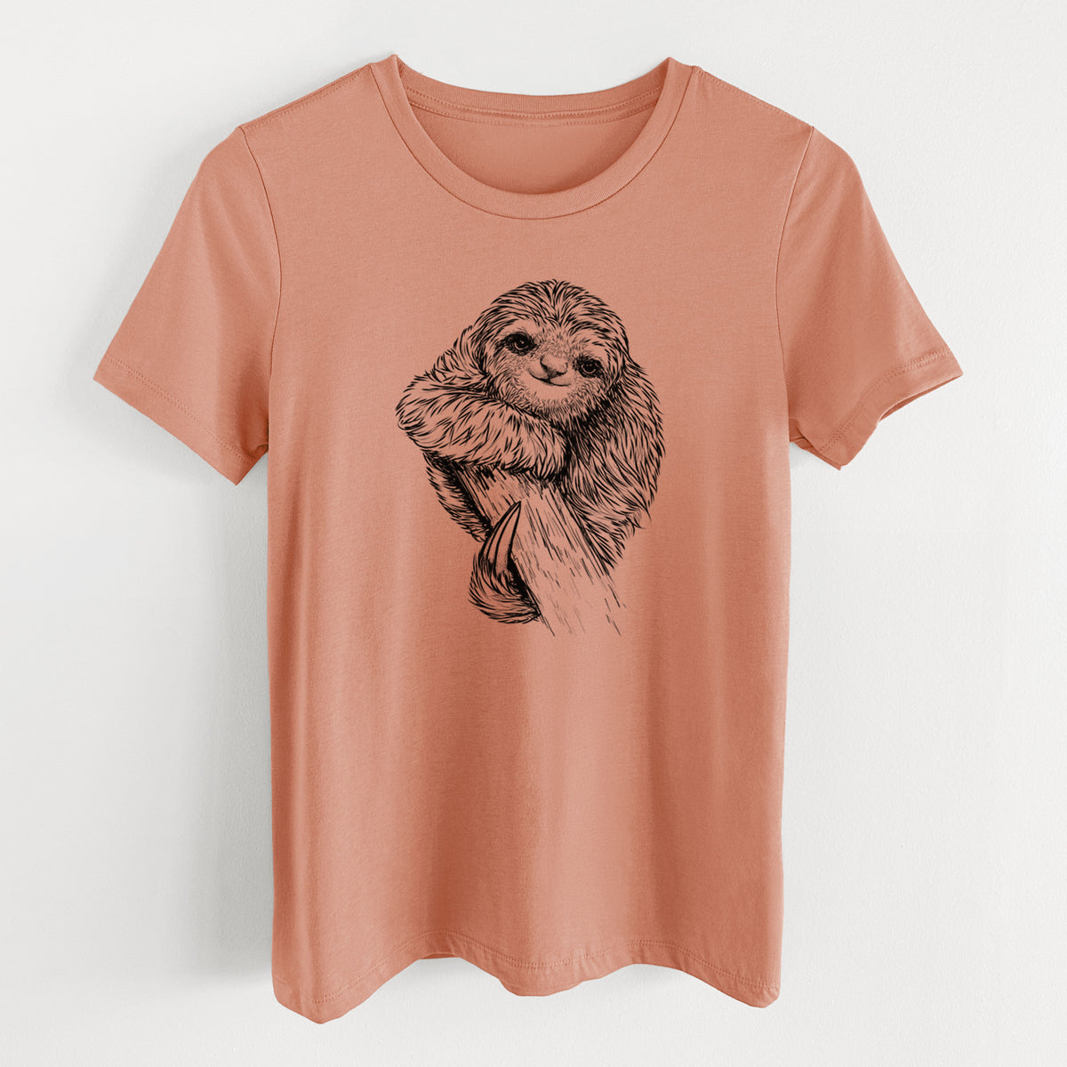 Terracotta orange women's relaxed fit cotton t-shirt laid flat, printed with a detailed black ink illustration of a smiling pygmy three-toed sloth hanging from a branch.