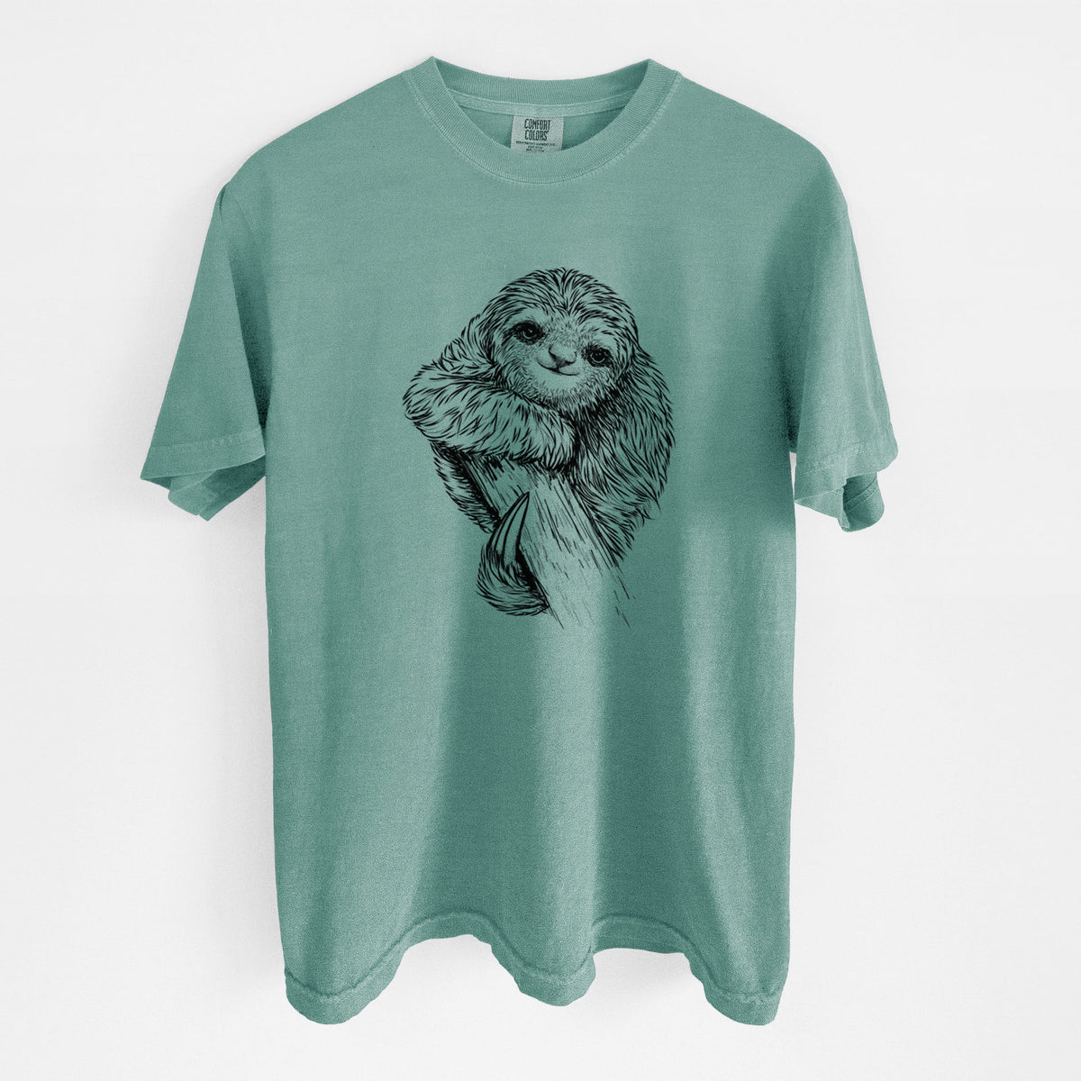 Reef green Comfort Colors t-shirt laid flat, printed with a detailed black ink illustration of a smiling pygmy three-toed sloth hanging from a branch.