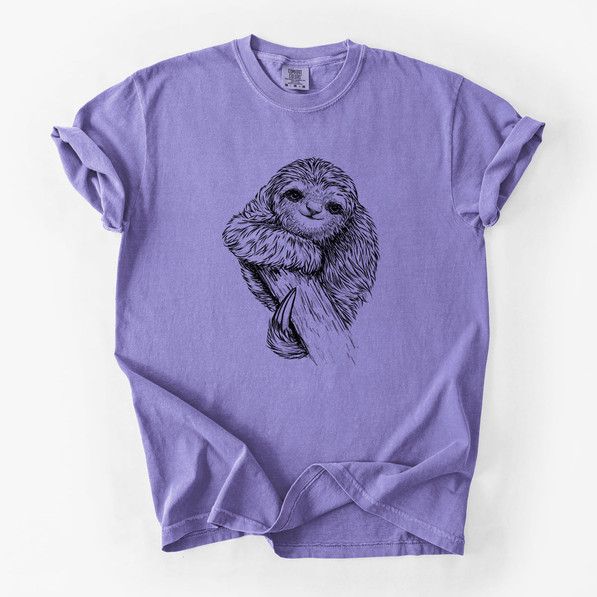 Violet purple Comfort Colors t-shirt laid flat, printed with a detailed black ink illustration of a smiling pygmy three-toed sloth hanging from a branch.