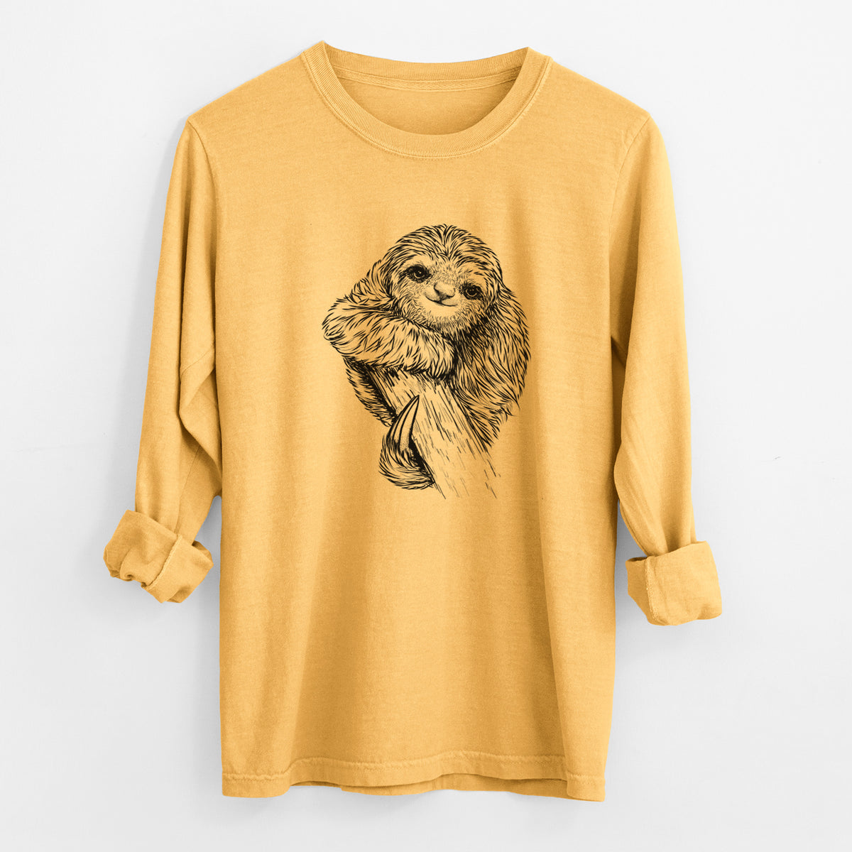 Golden wheat yellow Comfort Colors long sleeve shirt laid flat with the cuffs rolled, printed with a detailed black ink illustration of a smiling pygmy three-toed sloth hanging from a branch.