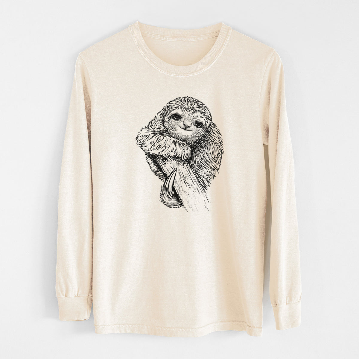 Ivory Comfort Colors long sleeve shirt laid flat, printed with a detailed black ink illustration of a smiling pygmy three-toed sloth hanging from a branch.