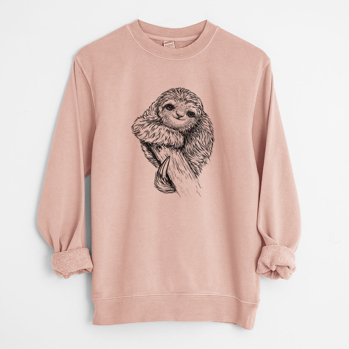 Dusty pink pigment dyed crewneck sweatshirt laid flat with the sleeves rolled, printed with a detailed black ink illustration of a smiling pygmy three-toed sloth hanging from a branch.