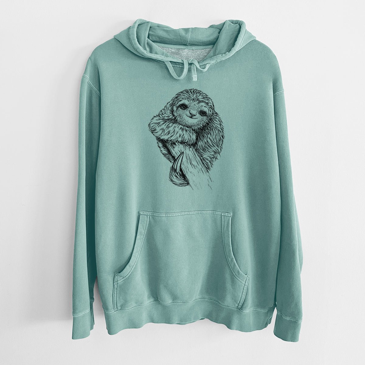 Mint green pigment dyed hoodie laid flat, printed with a detailed black ink illustration of a smiling pygmy three-toed sloth hanging from a branch.