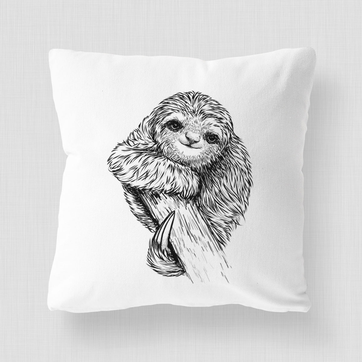 White pillow cover printed with a detailed black ink illustration of a smiling pygmy three-toed sloth hanging from a branch.