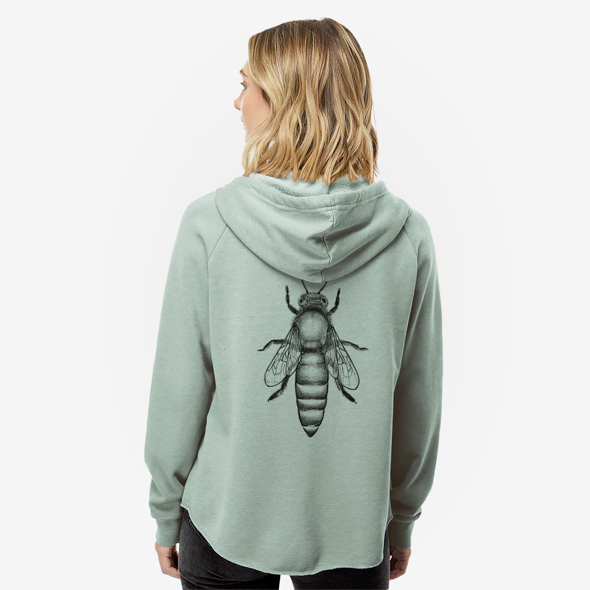 Woman wearing a sage green women's Cali Wave zip-up sweatshirt printed with a detailed black ink illustration of a queen honey bee, seen from above, seen from behind.