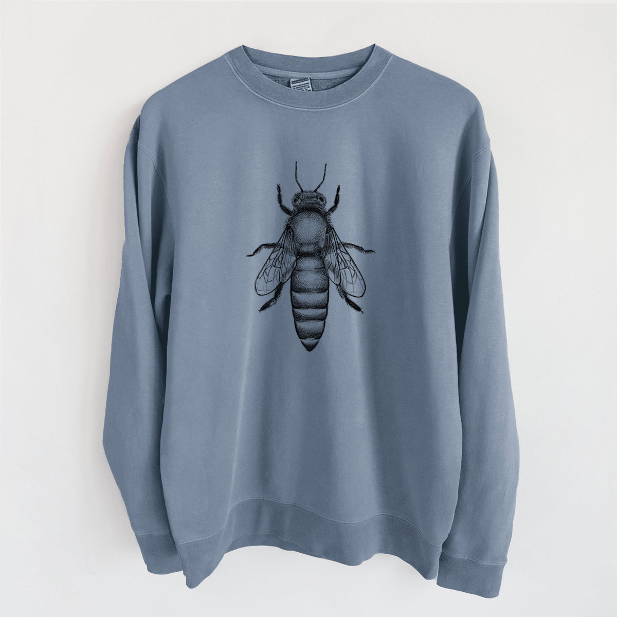 Slate blue pigment dyed crewneck sweatshirt laid flat, printed with a detailed black ink illustration of a queen honey bee, seen from above.