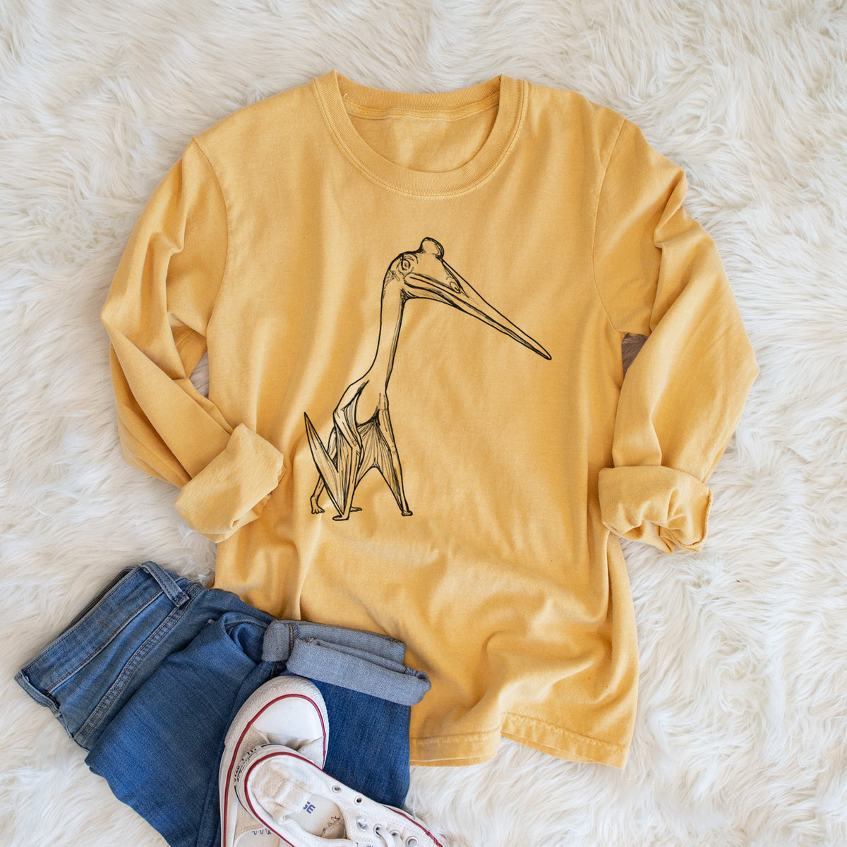 Golden wheat yellow Comfort Colors long sleeve shirt printed with a black ink illustration of a Quetzalcoatlus pterosaur standing on all fours, shown in a lifestyle photo.