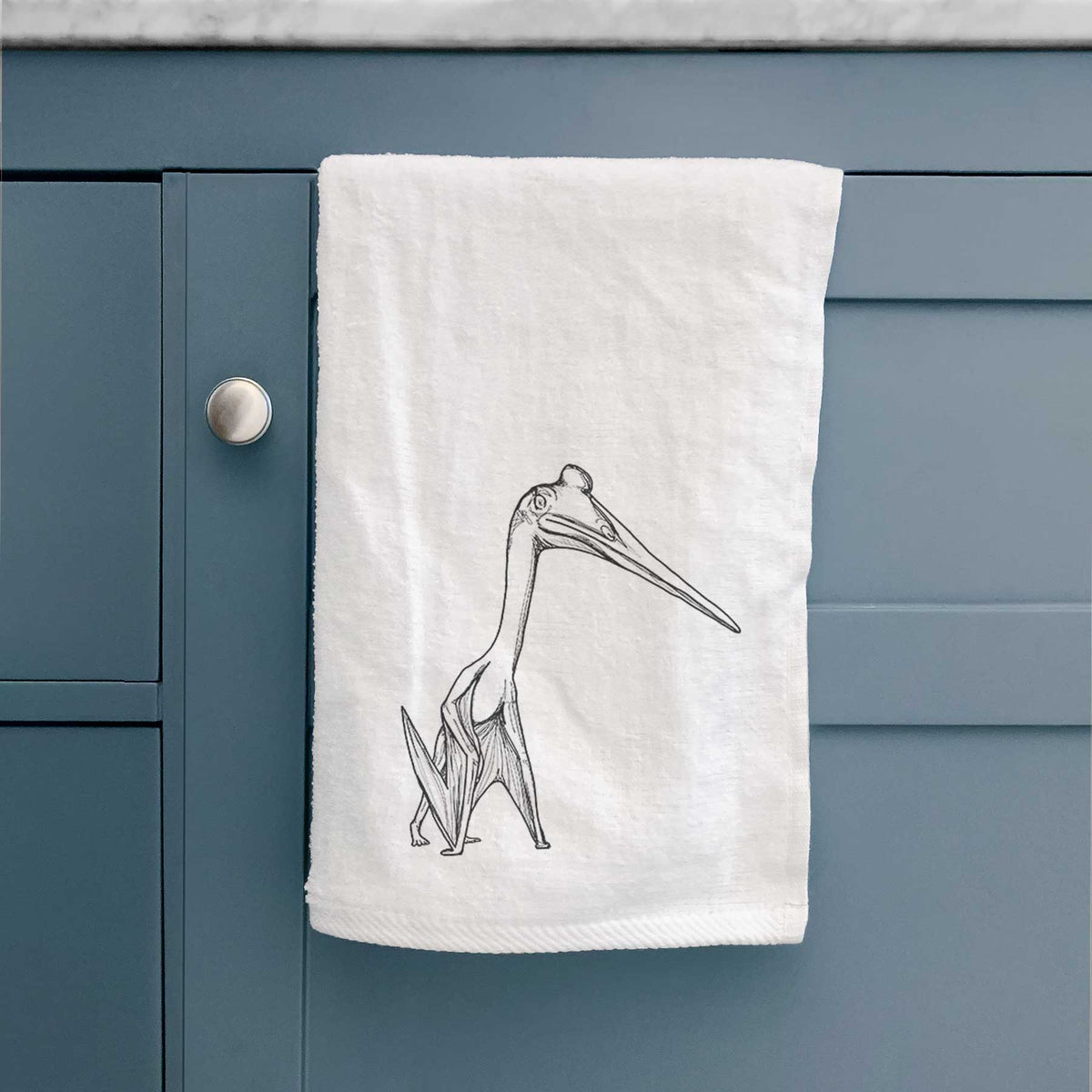 White hand towel printed with a black ink illustration of a Quetzalcoatlus pterosaur standing on all fours.