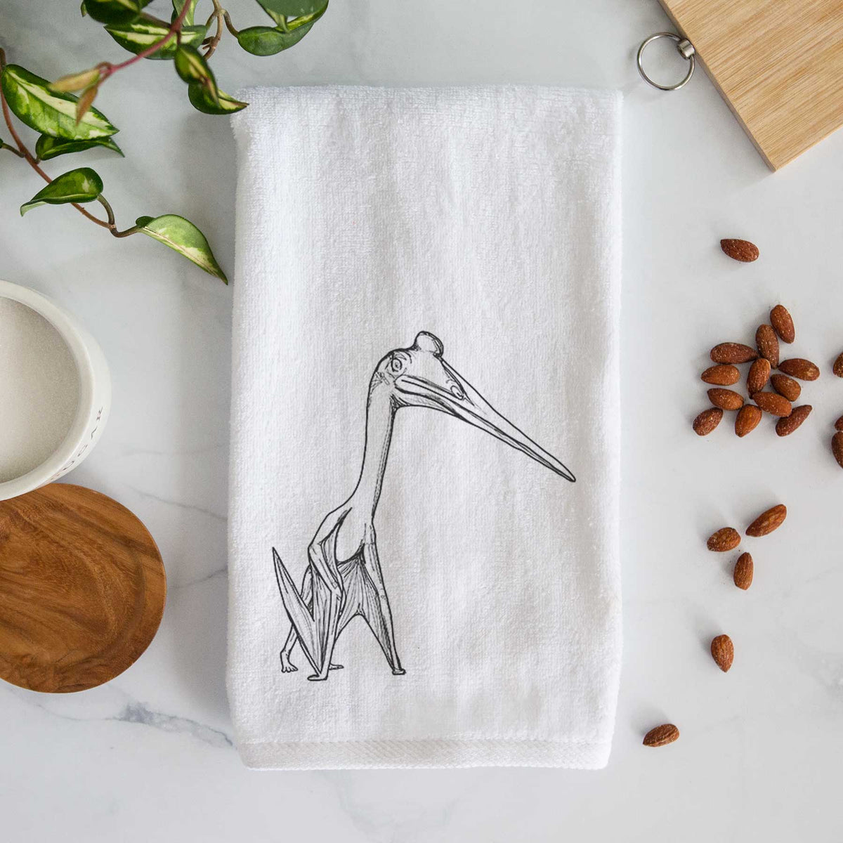 White hand towel printed with a black ink illustration of a Quetzalcoatlus pterosaur standing on all fours.