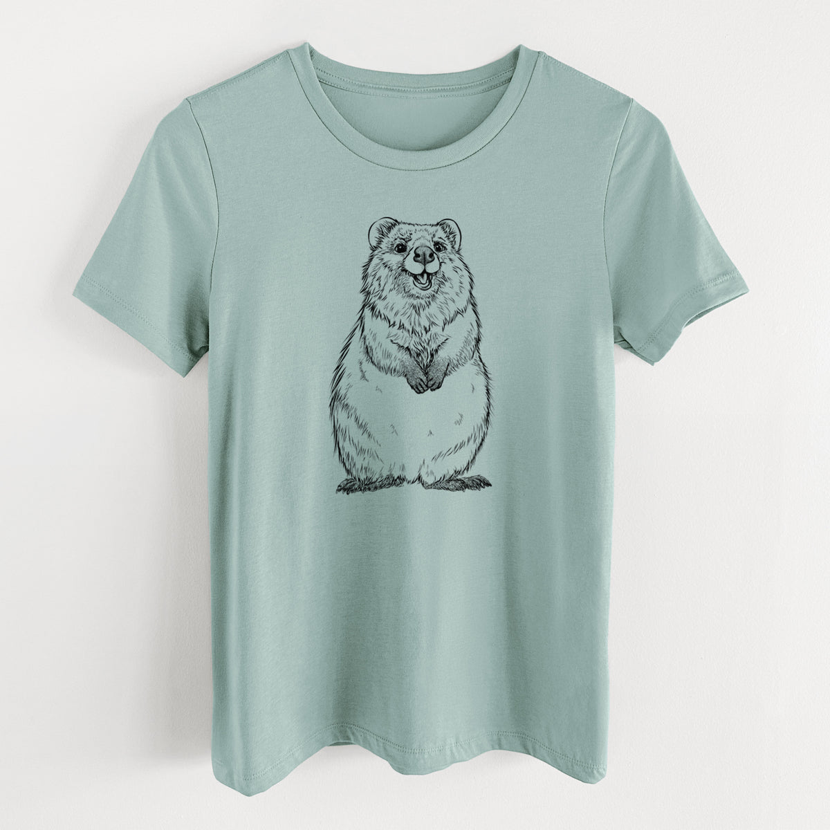 Dusty blue women's relaxed fit cotton t-shirt laid flat, printed with a black ink illustration of a smiling quokka sitting upright.