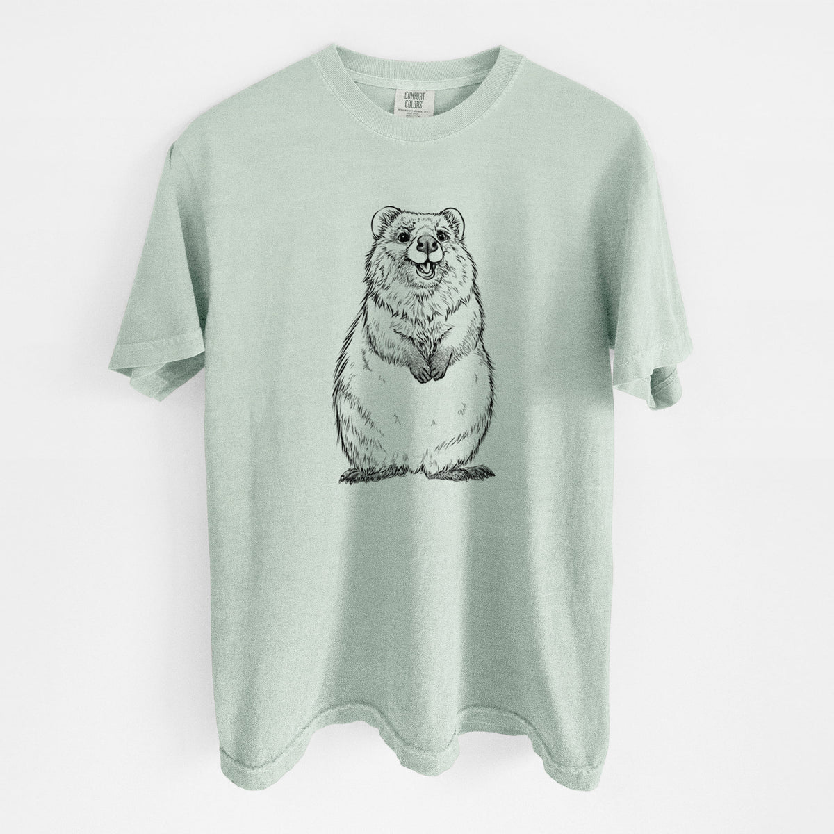 Bay green Comfort Colors t-shirt laid flat, printed with a black ink illustration of a smiling quokka sitting upright.