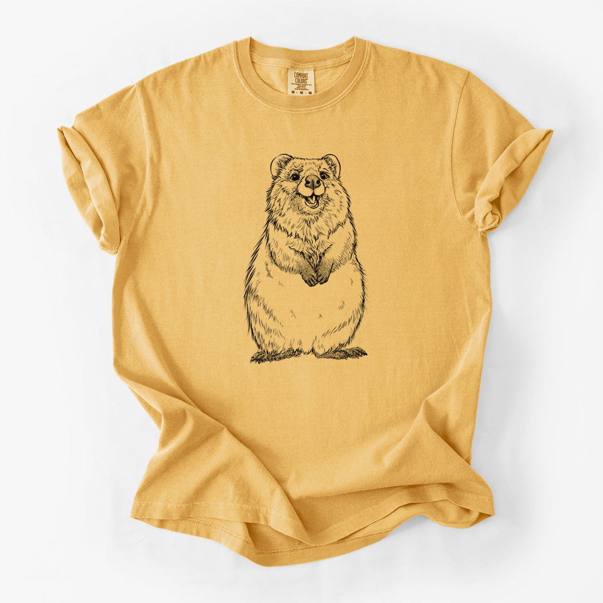 Golden wheat yellow Comfort Colors t-shirt laid flat, printed with a black ink illustration of a smiling quokka sitting upright.