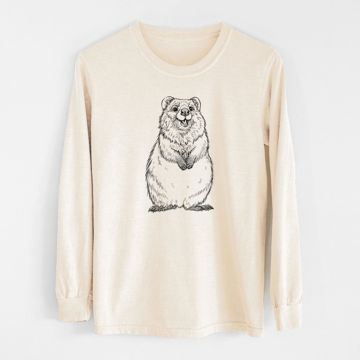 Ivory Comfort Colors long sleeve shirt laid flat, printed with a black ink illustration of a smiling quokka sitting upright.