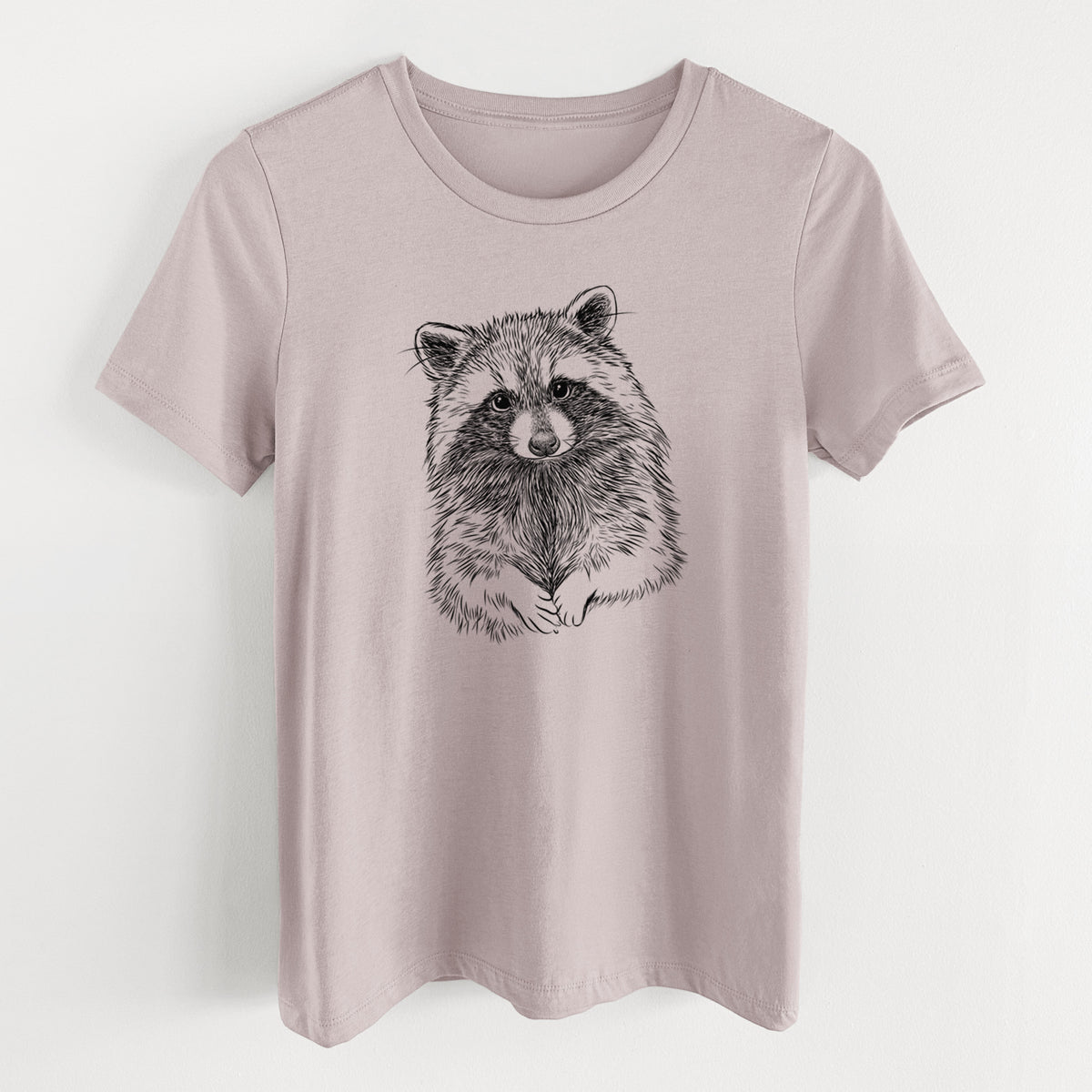 Pink gravel women's relaxed fit cotton t-shirt laid flat, printed with a detailed black ink portrait of a raccoon with its front paws resting in front of it.