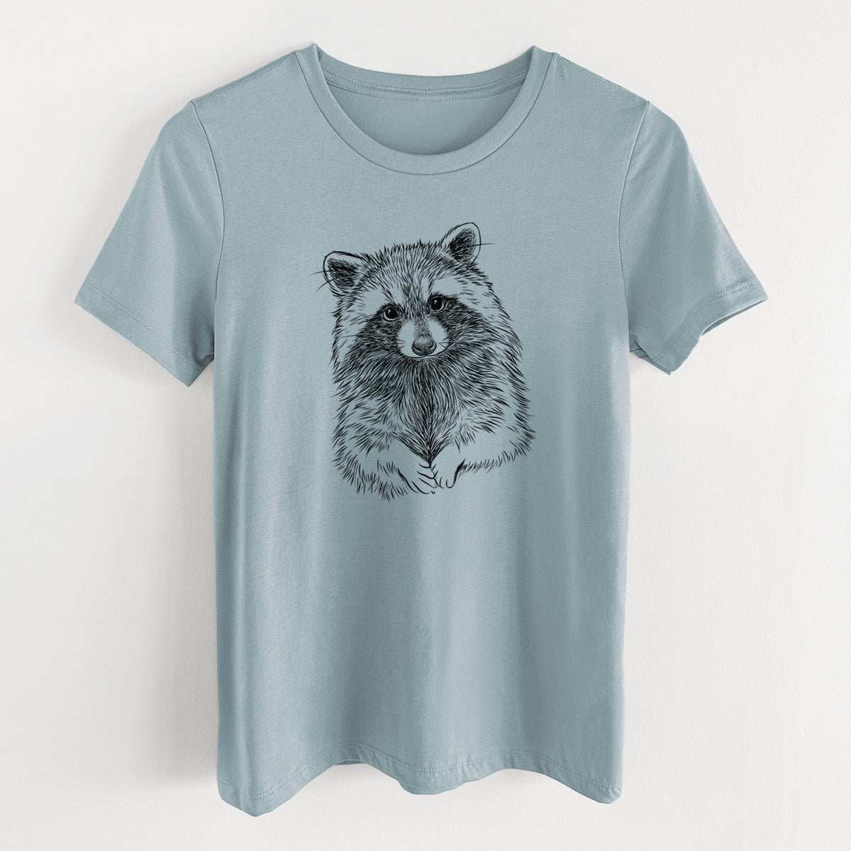 Vintage denim women's relaxed fit cotton t-shirt laid flat, printed with a detailed black ink portrait of a raccoon with its front paws resting in front of it.