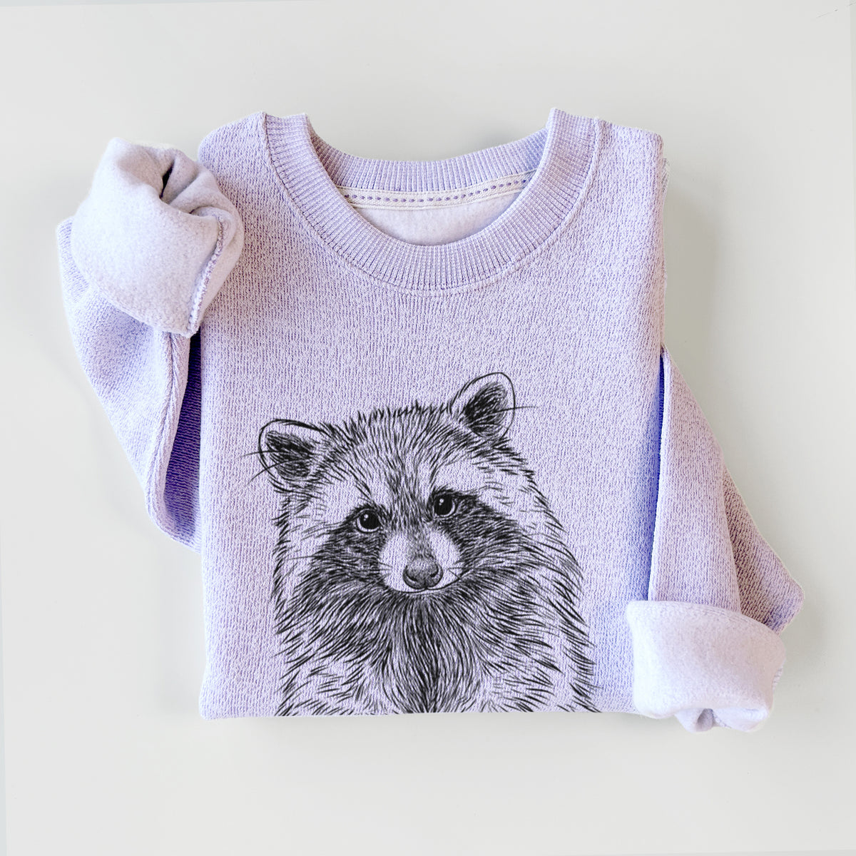 Ice purple knit sweatshirt printed with a detailed black ink portrait of a raccoon with its front paws resting in front of it, styled flat.