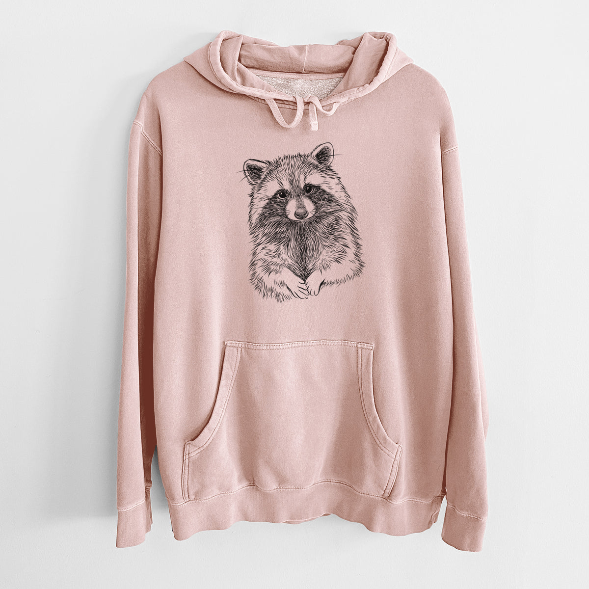 Dusty pink pigment dyed hoodie laid flat, printed with a detailed black ink portrait of a raccoon with its front paws resting in front of it.