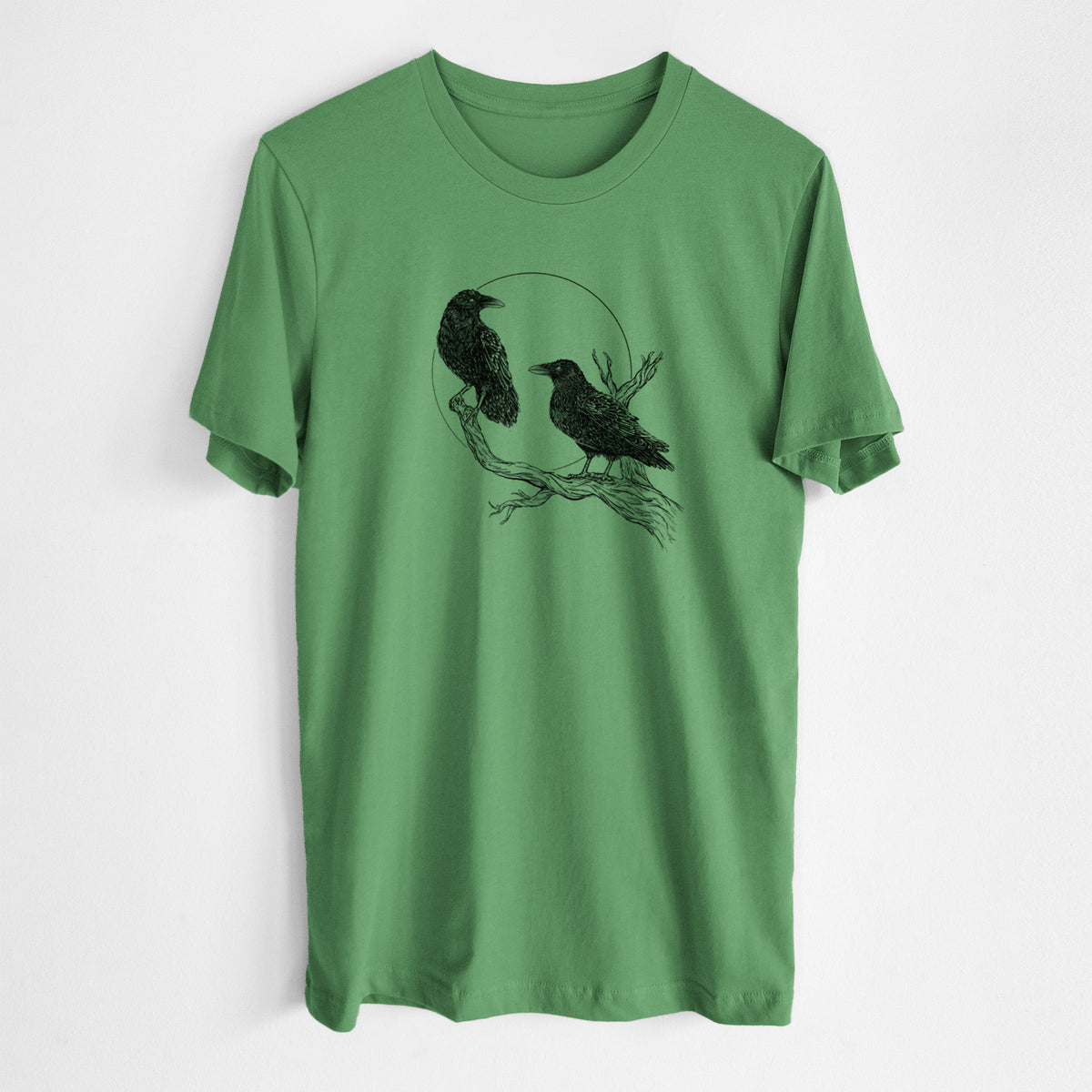 Leaf green lightweight cotton t-shirt laid flat, printed with a black ink illustration of two ravens perched on a branch in front of a full moon.