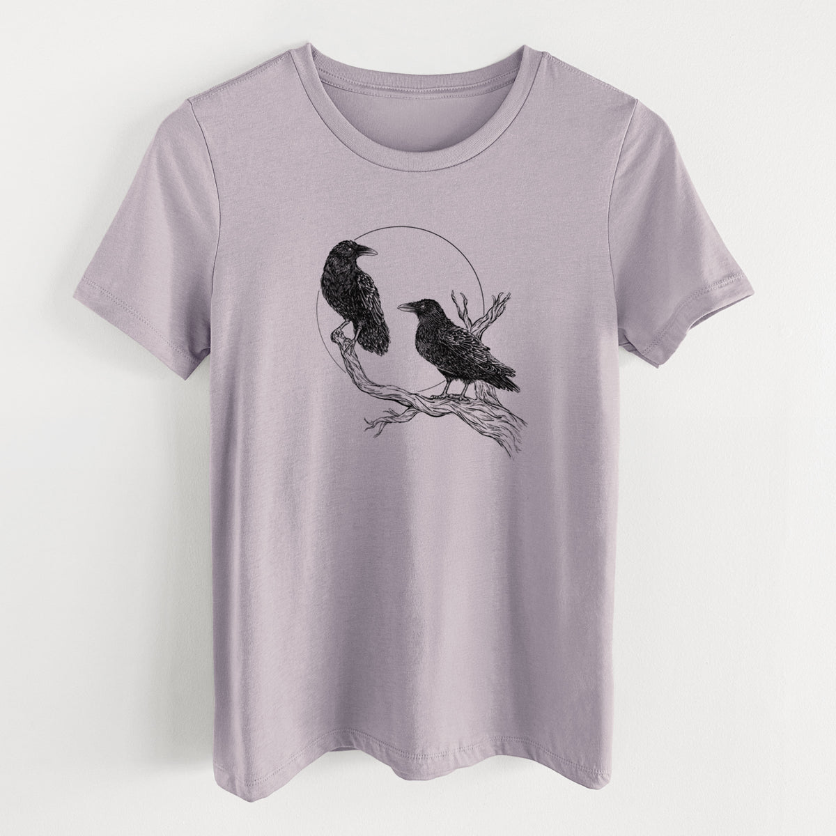 Light violet women's relaxed fit cotton t-shirt laid flat, printed with a black ink illustration of two ravens perched on a branch in front of a full moon.