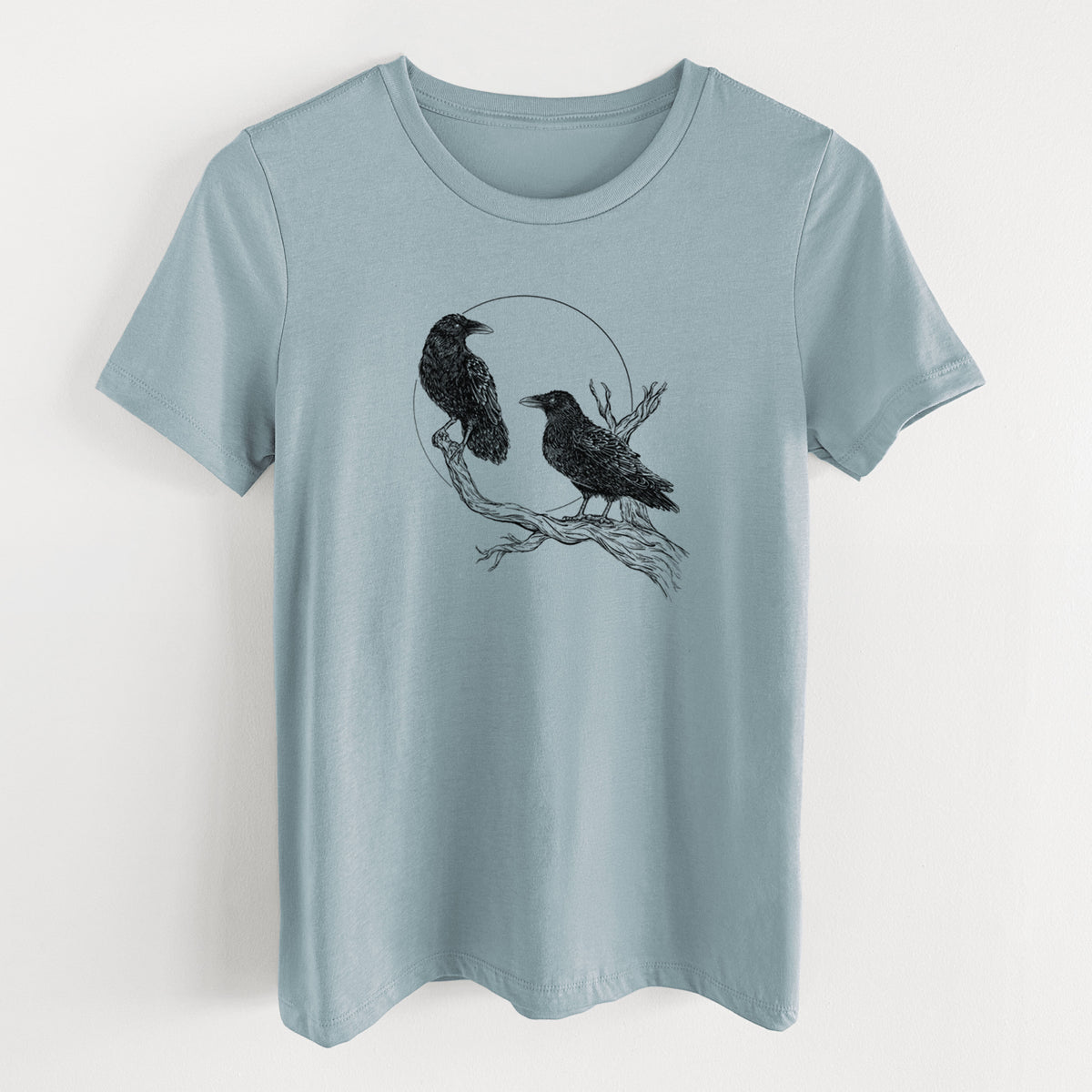 Vintage denim women's relaxed fit cotton t-shirt laid flat, printed with a black ink illustration of two ravens perched on a branch in front of a full moon.