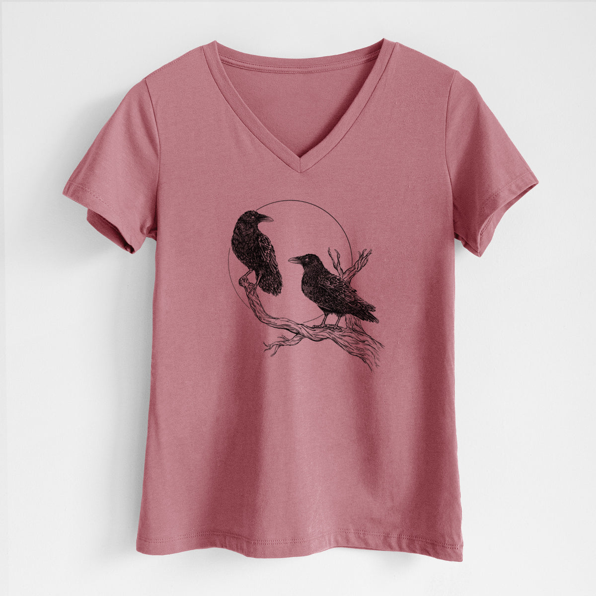 Mauve pink women's relaxed fit cotton V-neck t-shirt laid flat, printed with a black ink illustration of two ravens perched on a branch in front of a full moon.