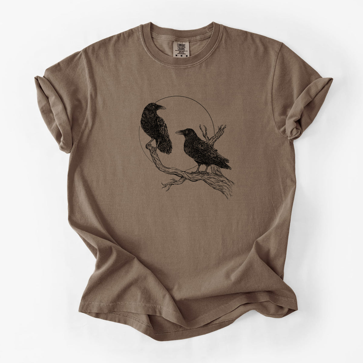Espresso brown Comfort Colors t-shirt laid flat, printed with a black ink illustration of two ravens perched on a branch in front of a full moon.