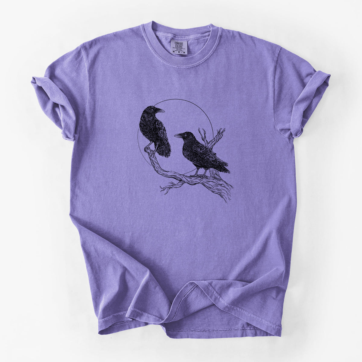 Violet purple Comfort Colors t-shirt laid flat, printed with a black ink illustration of two ravens perched on a branch in front of a full moon.