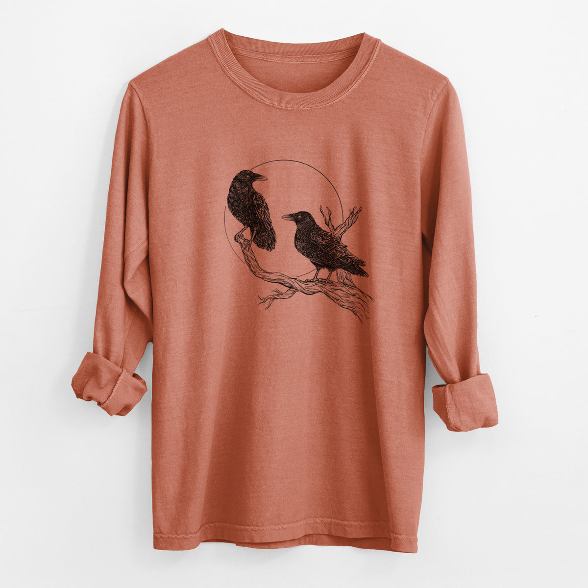 Yam burnt orange Comfort Colors long sleeve shirt laid flat with the cuffs rolled, printed with a black ink illustration of two ravens perched on a branch in front of a full moon.