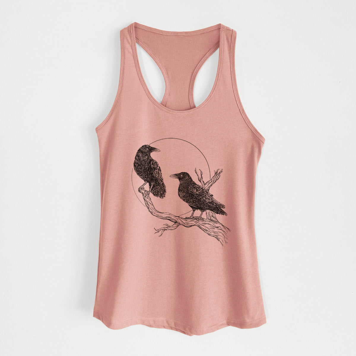 Desert pink women's racerback tank top laid flat, printed with a black ink illustration of two ravens perched on a branch in front of a full moon.