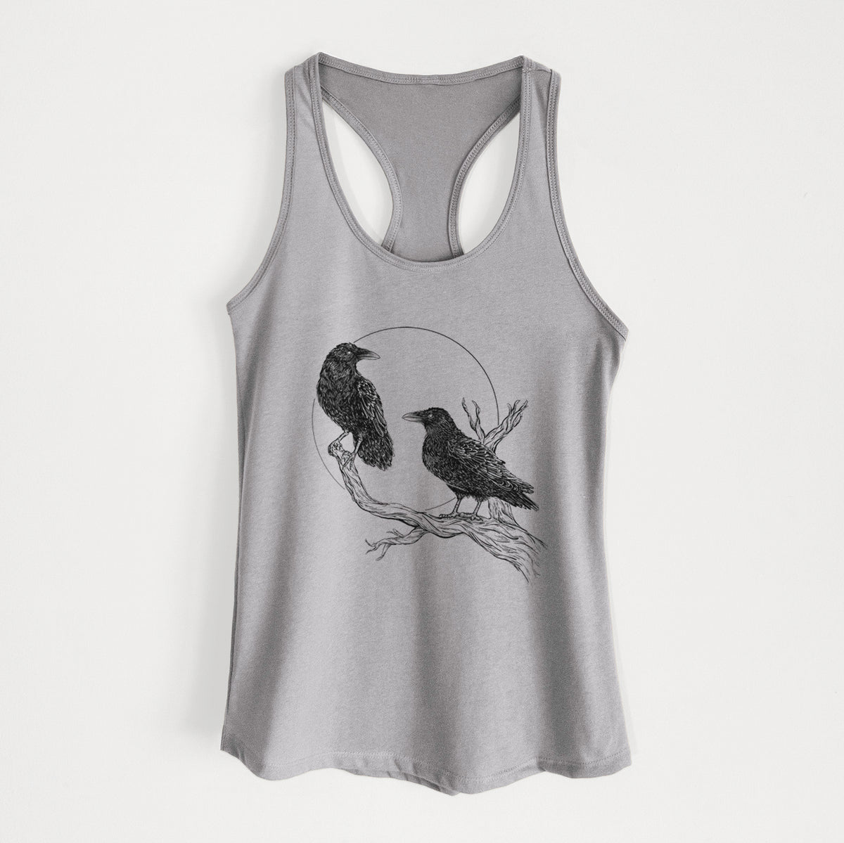 Heather grey women's racerback tank top laid flat, printed with a black ink illustration of two ravens perched on a branch in front of a full moon.
