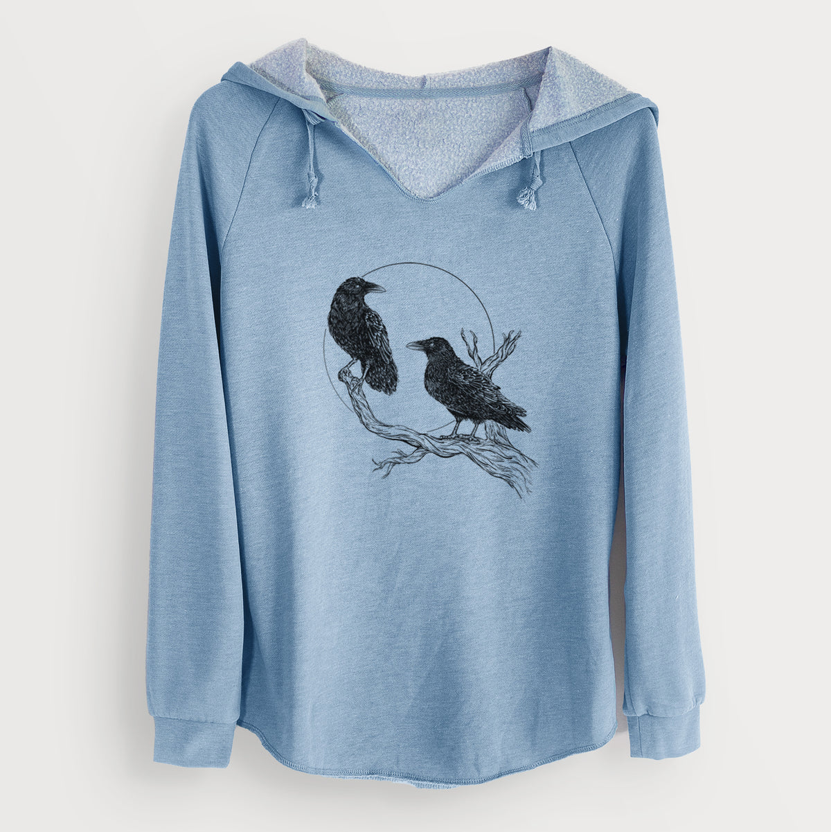 Misty blue women's Cali Wave hooded sweatshirt laid flat, printed with a black ink illustration of two ravens perched on a branch in front of a full moon.