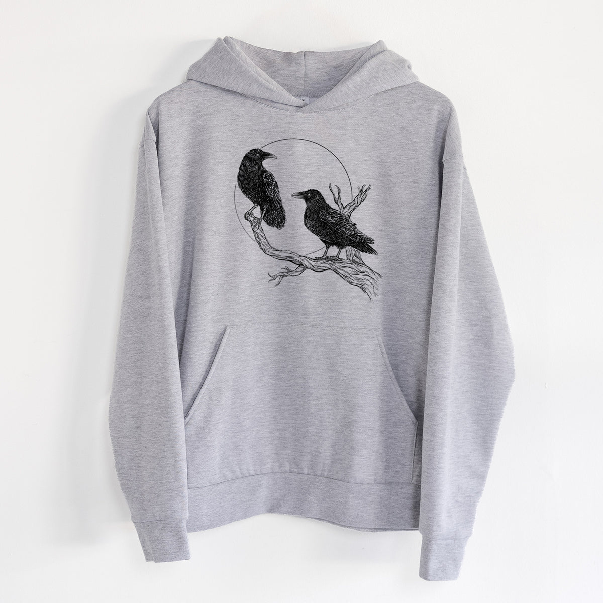 Midnight Ravens - Statement Midweight Hoodie in Heather Grey, hanging on a white wall, with a front kangaroo pocket and no drawcords.