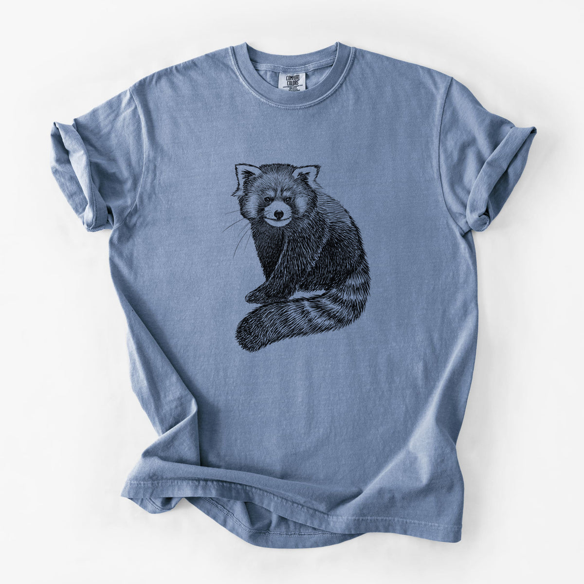 Blue jean Comfort Colors t-shirt laid flat, printed with a detailed black ink illustration of a red panda sitting with its striped tail wrapped around.